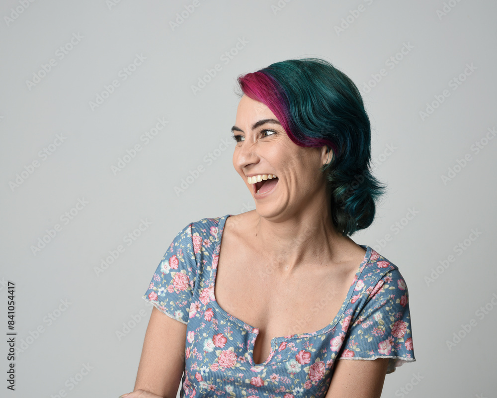 a close up head and shoulders portrait of young alternative female model, with pink and grey shaved undercut hair style, wearing a floral blue top. dramatically pulling expressive facial expressions. a close up head and shoulders portrait of young alternative female model, with pink and grey shaved undercut hair style, wearing a floral blue top. dramatically pulling expressive facial expressions.
