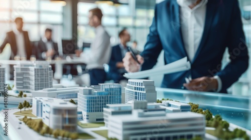 real estate developer and businessmen team working on new modern business park project in office. complex buildings scale model