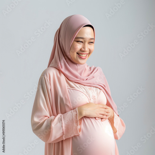 Young pregnant Malaysian woman in tradition pink outfit
