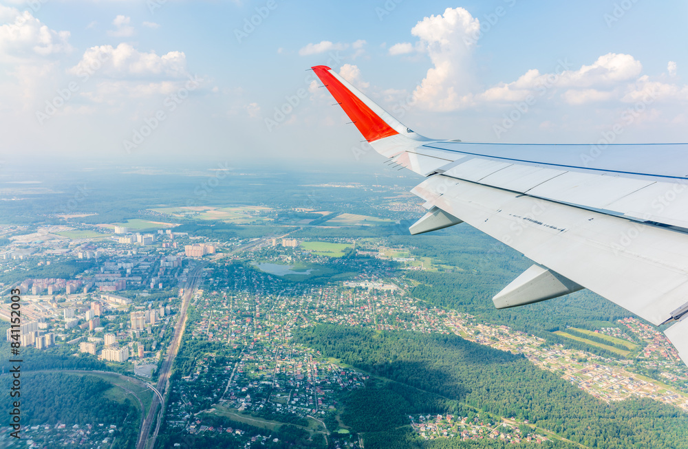 Fototapeta premium View from the airplane window during taking off on a clear summer morning