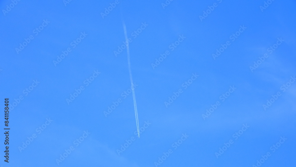 White contrail stretching straight into the blue sky White contrail stretching straight into the blue sky