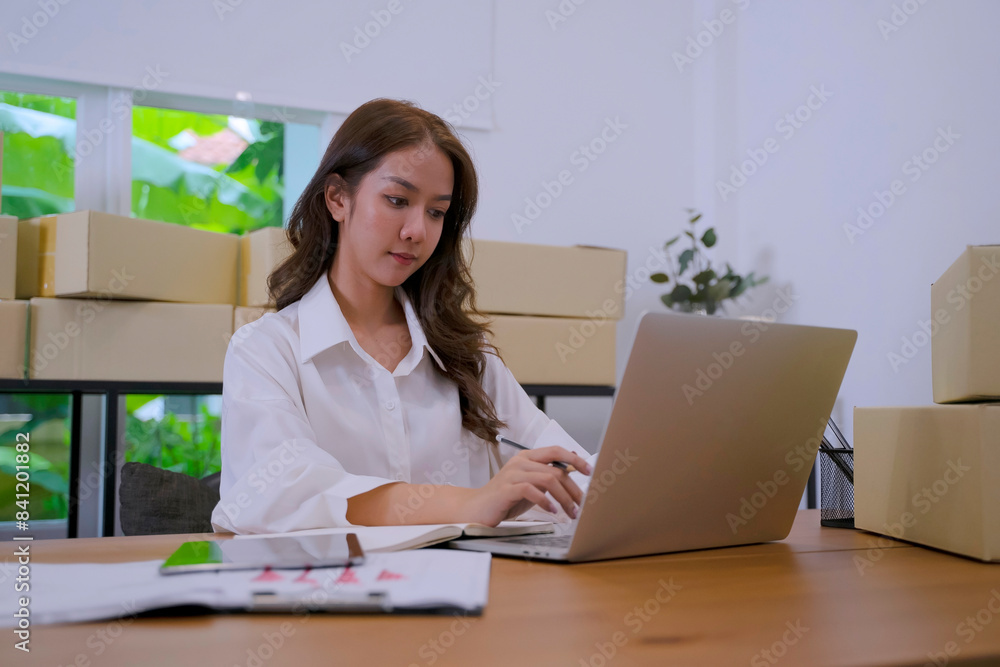 Young female entrepreneur is packing merchandise at home. Young female entrepreneur is packing merchandise at home.