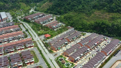 Aerial views drone flyover Goodview Heights residential neighborhood capturing rows of double-storey terraced houses, hillside landscape and mountainous terrains, Kajang, Malaysia, Southeast Asia. photo