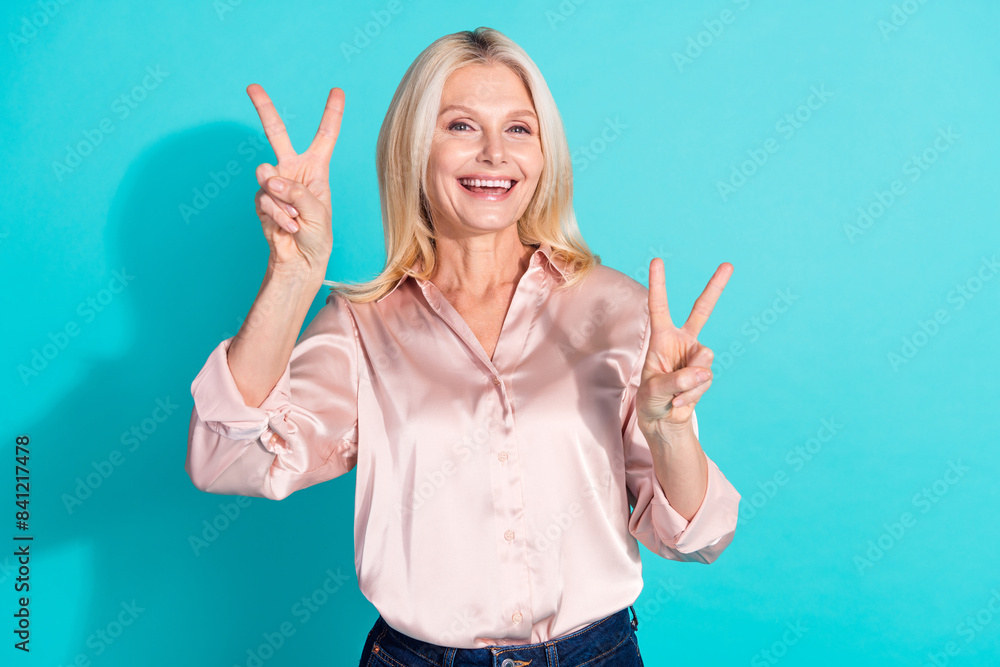 Photo of pretty elegant lady show v-sign wear shirt isolated on teal color background Photo of pretty elegant lady show v-sign wear shirt isolated on teal color background