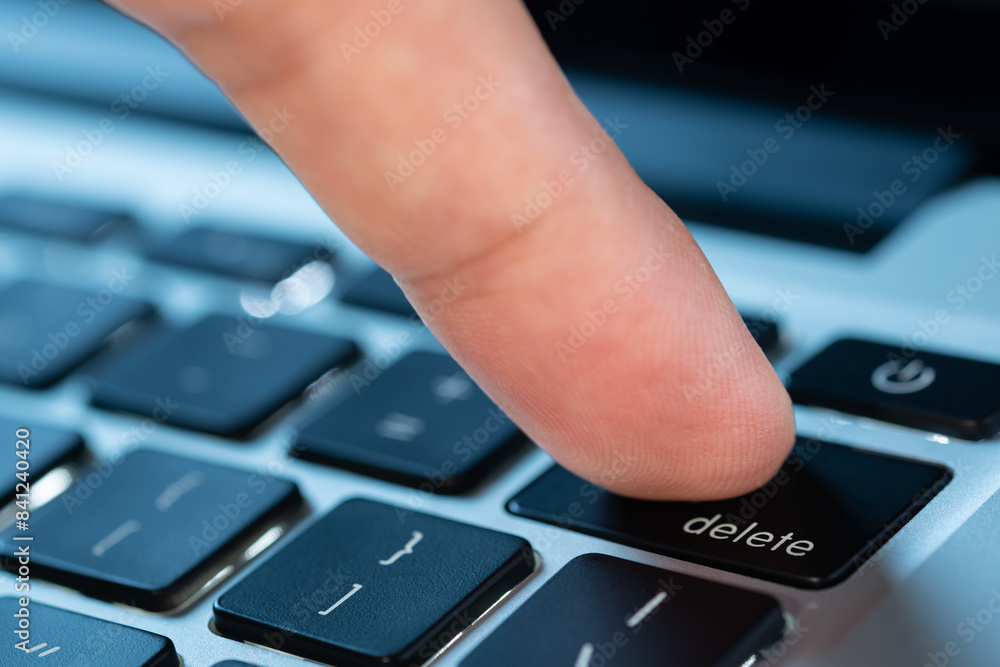 Finger of the computer user, he presses the delete button on the computer keyboard Finger of the computer user, he presses the delete button on the computer keyboard