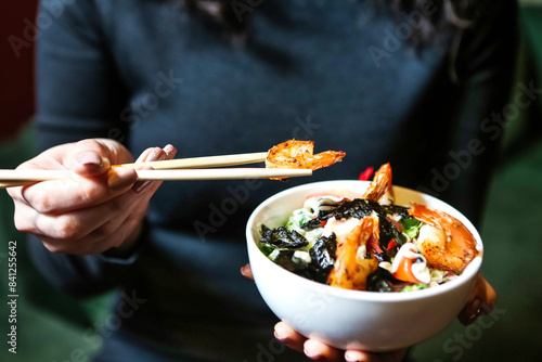 Woman Holding Bowl of Food With Chopsticks photo