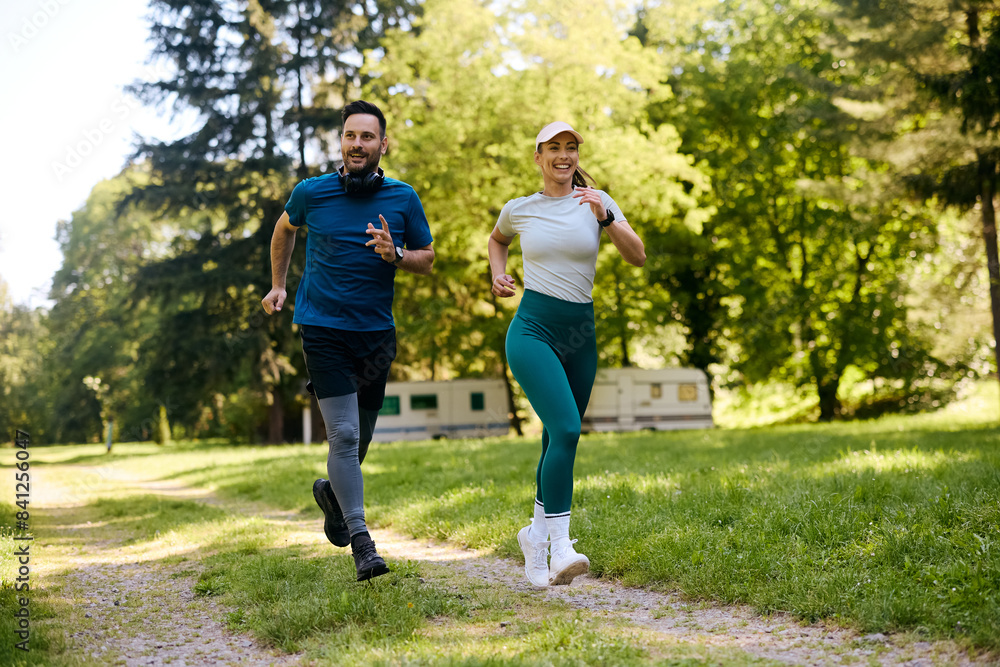 Happy athletic couple jogging during sports training in nature. Happy athletic couple jogging during sports training in nature.