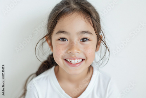 a little girl smiling with a toothbrush in her mouth