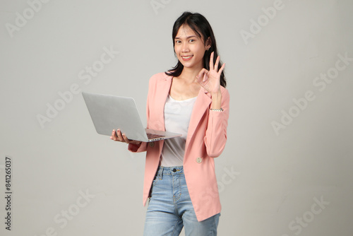 happy asian woman wearing formal casual outfit holding laptop computer giving approval ok sign gesture on isolated background