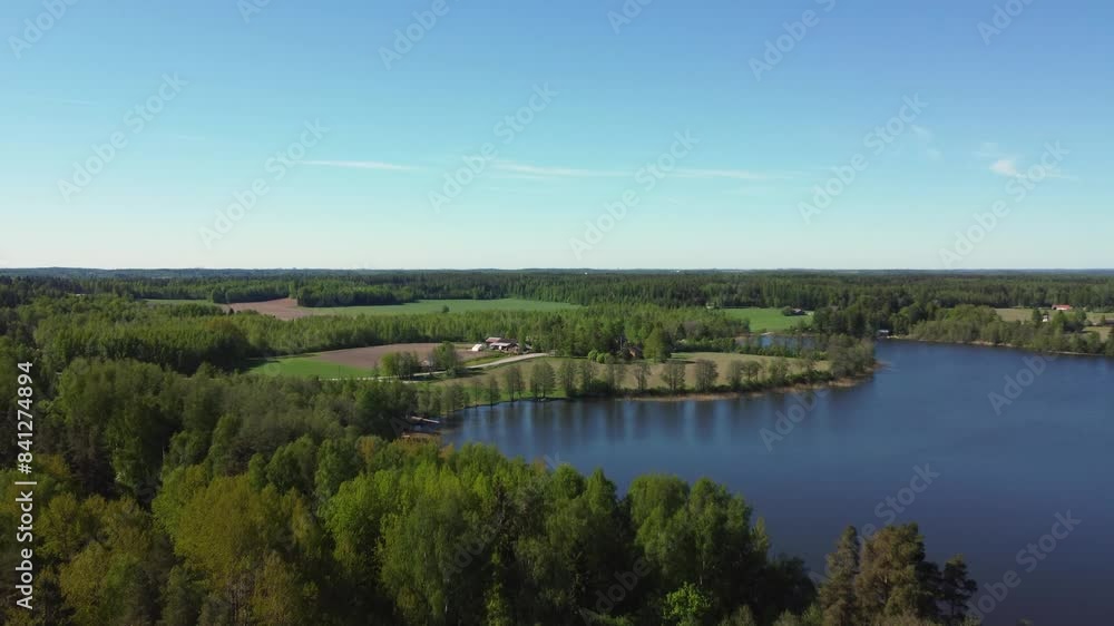 Aerial flight over bright green trees to rural deep blue northern lake Aerial flight over bright green trees to rural deep blue northern lake