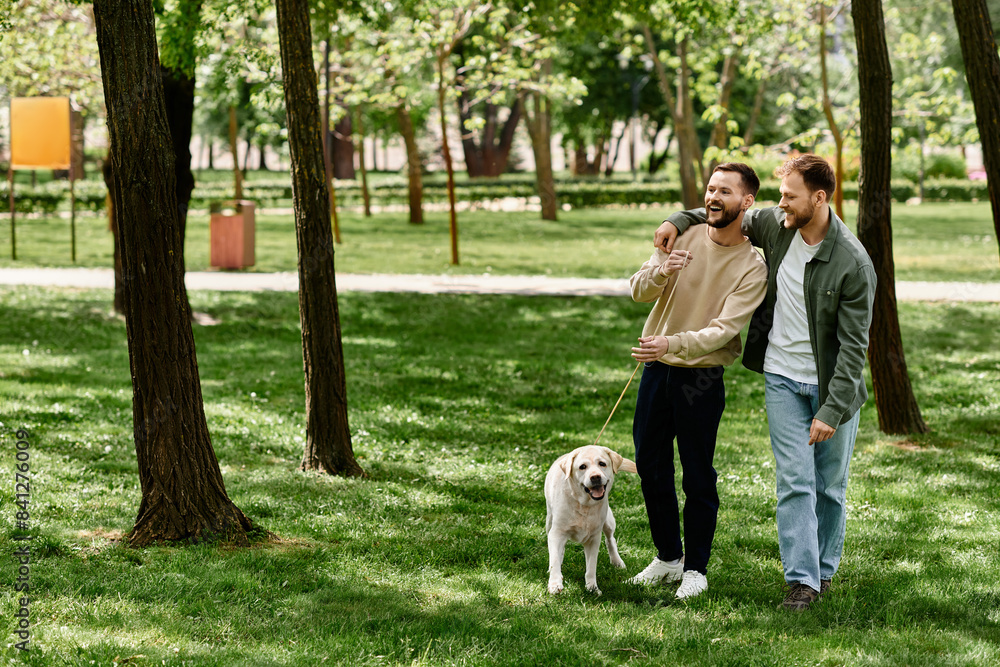 A gay couple with beards walks through a green park with their labrador retriever. A gay couple with beards walks through a green park with their labrador retriever.