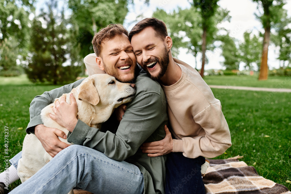 Fototapeta premium A bearded gay couple shares a laugh with their labrador dog while enjoying a picnic in a green park.