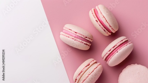 Pink macaroons on a pink and white backdrop with a sweet ambiance flat lay image with copy space