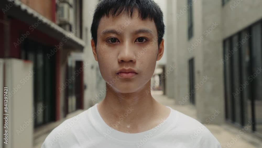 Close-Up of a Sad and Exhausted Boy Standing in a Poor Neighborhood, Reflecting Hardship and Resilience. Asian Teenager Looking at Camera Outside. Close-Up of a Sad and Exhausted Boy Standing in a Poor Neighborhood, Reflecting Hardship and Resilience. Asian Teenager Looking at Camera Outside.