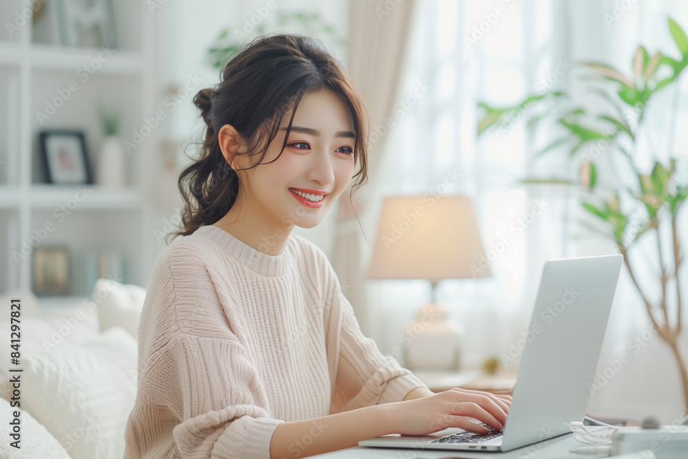 リビングでノートパソコンを使う若い女性 リビングでノートパソコンを使う若い女性