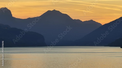 A beautiful sunset in the region of Walensee, Wessen, Amden, Quinten, Mols, and Walenstadt, with the stunning silhouettes of the Swiss Alps in the background. photo