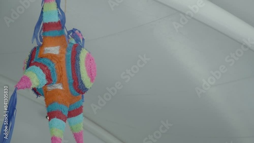 Colorful traditional Mexican star-shaped piñata hanging from the white ceiling. Latin American culture. Mexico.