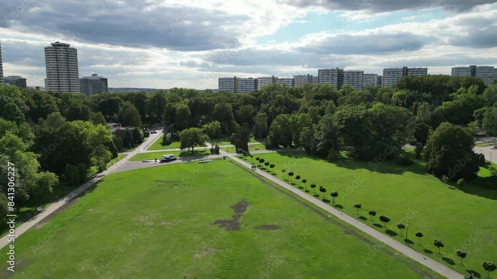 Parkside during a beautiful summer day surrounded by lush greenery, grass, and trees under a blue sky with buildings in the distance Parkside during a beautiful summer day surrounded by lush greenery, grass, and trees under a blue sky with buildings in the distance