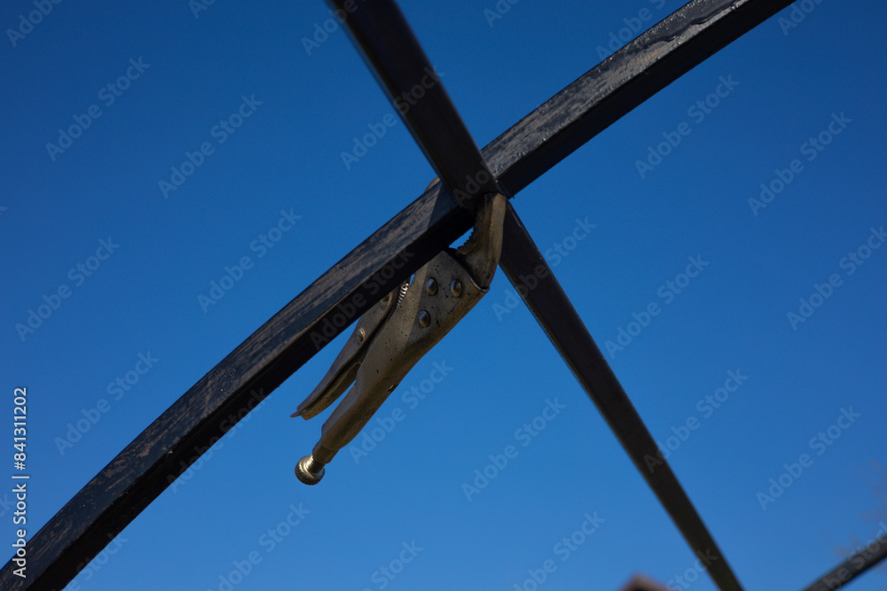 Two metal pipes are fastened together with a vice so that they can then be welded conveniently and evenly. Preparing metal pipes for welding. The pipes are held together with a clamp.