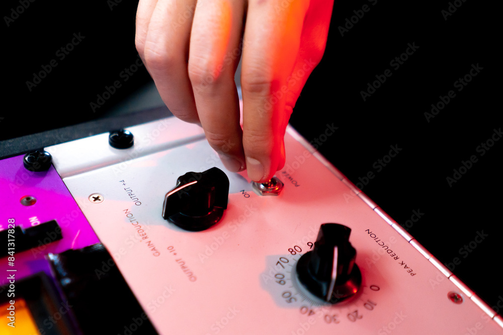 Obraz premium in the recording room under neon lighting professional remote control for adjusting the sound the director turns on the toggle switch on the amp