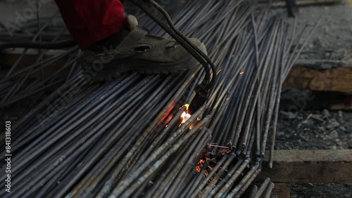 Construction Worker Welding Steel Rebars with Sparks at Building Site