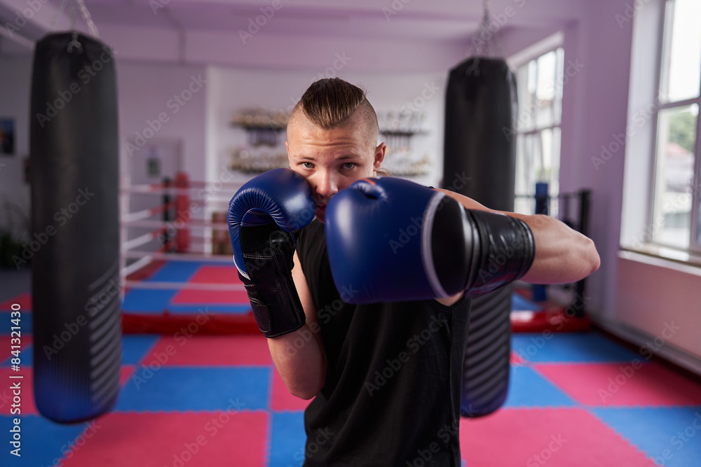 Young boxer doing shadow boxing in a gym