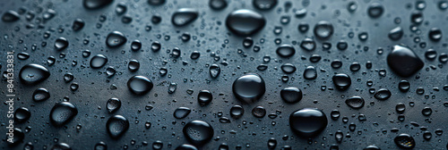 Marvel at a cluster of liquid drops atop a black surface, each featuring a smaller water droplet nestled beneath.Generative AI