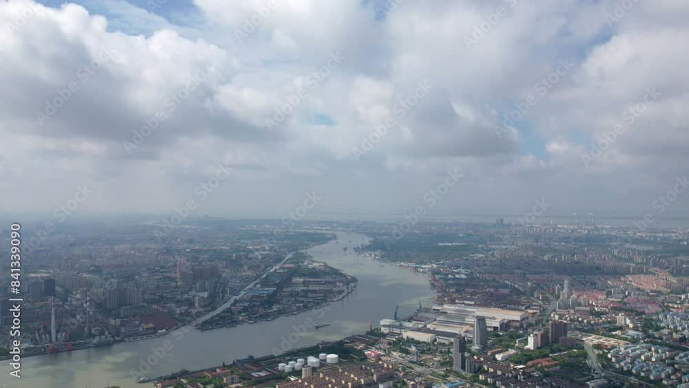 Drone view of Shanghai city in sunny cloudy day, high angle view of ships sailing on Huangpu river and modern buildings with white clouds moving on blue sky, 4k time lapse footage. Drone view of Shanghai city in sunny cloudy day, high angle view of ships sailing on Huangpu river and modern buildings with white clouds moving on blue sky, 4k time lapse footage.