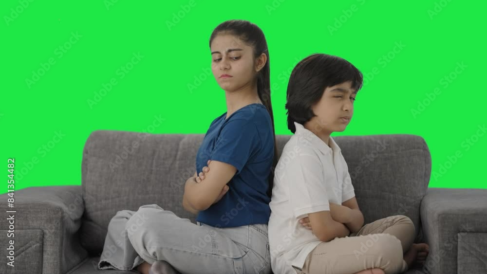 Angry Indian siblings sitting back to back and not talking Green screen Angry Indian siblings sitting back to back and not talking Green screen