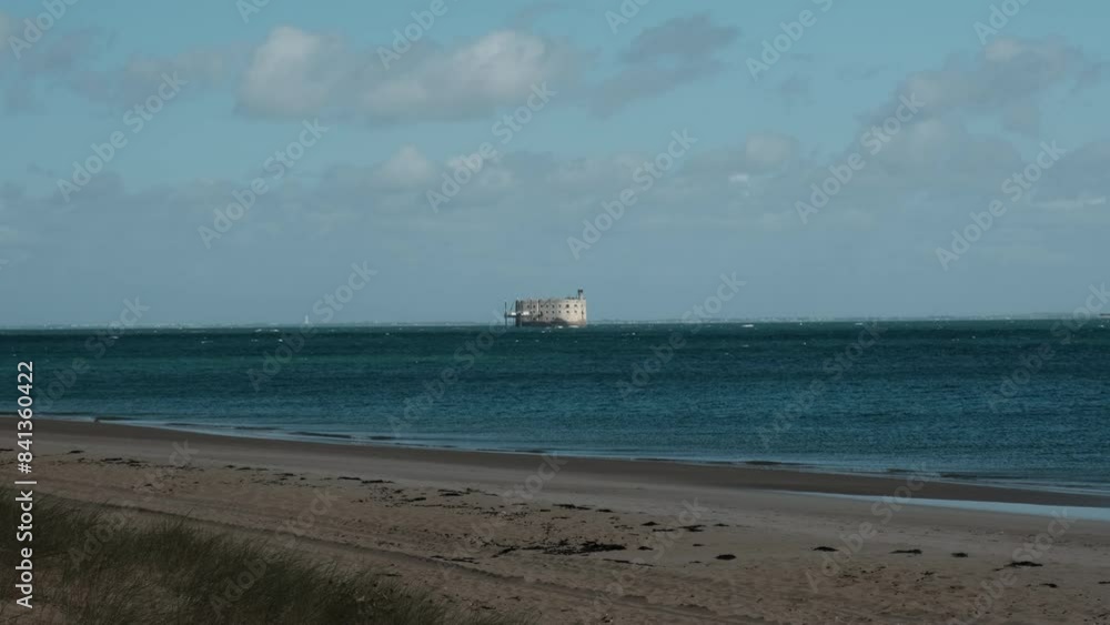 ancient Fort Boyard along the coastline of the atlantic ocean of Oleron Island during summer with turquoise ocean and scenic clouds. ancient Fort Boyard along the coastline of the atlantic ocean of Oleron Island during summer with turquoise ocean and scenic clouds.