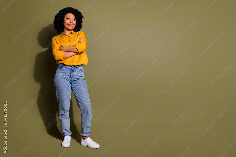 Full length portrait of pretty lady folded arms look empty space wear yellow shirt isolated on khaki color background Full length portrait of pretty lady folded arms look empty space wear yellow shirt isolated on khaki color background