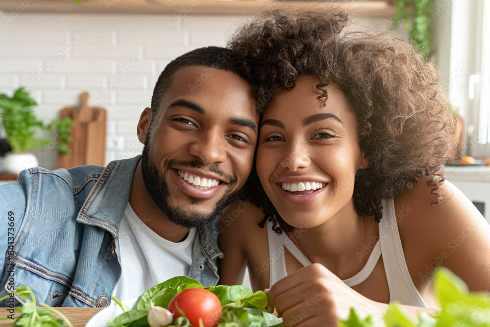 a man and woman are smiling while sitting at a table with a salad a man and woman are smiling while sitting at a table with a salad