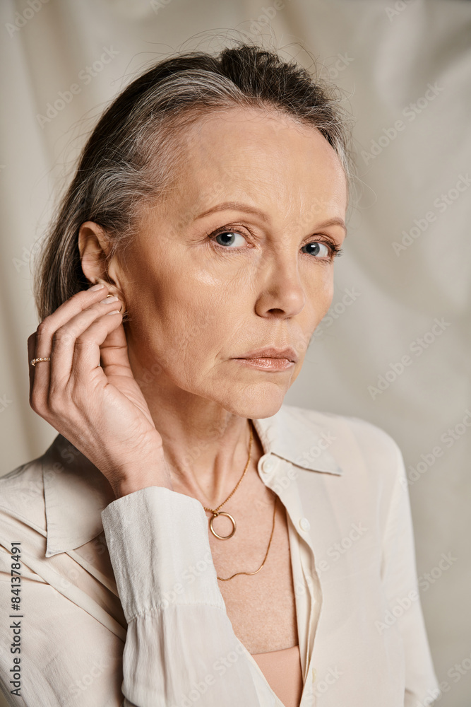 Mature woman exudes grace in a white shirt, striking a pose. Mature woman exudes grace in a white shirt, striking a pose.