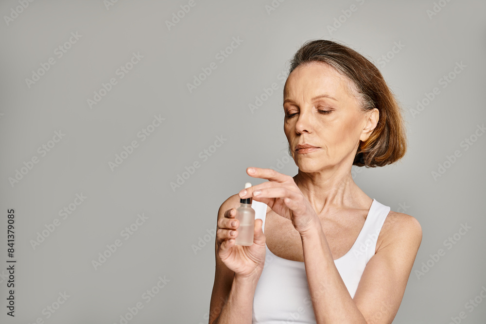 A woman gracefully holds a bottle of serum, embodying serenity and healing. A woman gracefully holds a bottle of serum, embodying serenity and healing.
