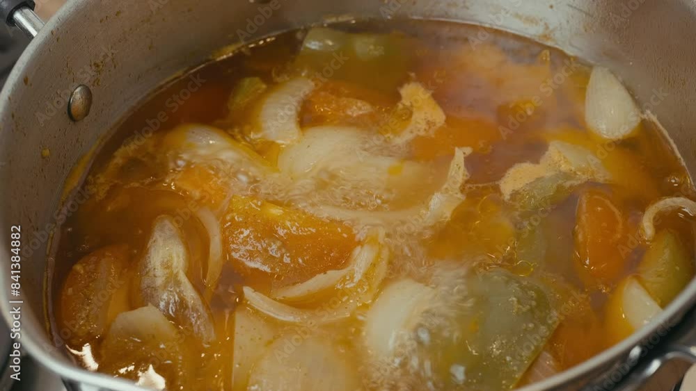 Cooking Video. Close up of food cooking simmering in a pan full of curry sauce, soup or stew placing ingredients herbs spices pan ready for cooking. Happy household chores healthy eating concept. Cooking Video. Close up of food cooking simmering in a pan full of curry sauce, soup or stew placing ingredients herbs spices pan ready for cooking. Happy household chores healthy eating concept.