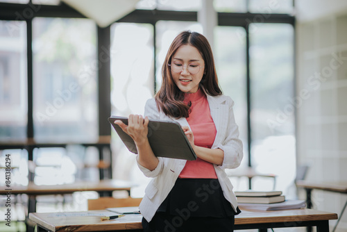 Attractive Asian businesswoman working at modern office with balance sheet documents. Accounting