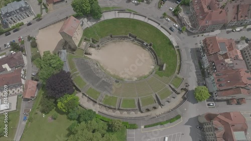 Aerial view of the Swiss medieval old town of Avenches with roman amphitheater on a cloudy spring day. Movie shot June 5th, 2024, Avenches, Switzerland.