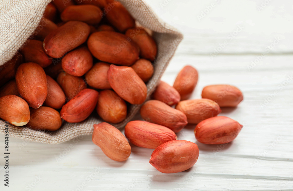 Fresh peanuts in sack on white wooden table, closeup Fresh peanuts in sack on white wooden table, closeup