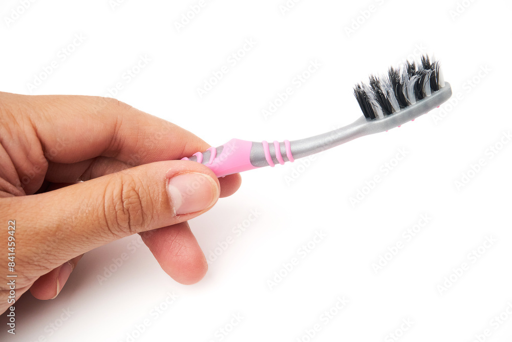 Hand holding old toothbrush that has been used and is worn out isolated on white background. Oral and teeth cleaning equipment. Hand holding old toothbrush that has been used and is worn out isolated on white background. Oral and teeth cleaning equipment.