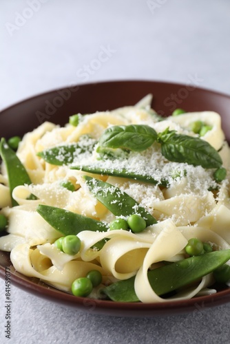 Delicious pasta with green peas and cheese on grey table, closeup