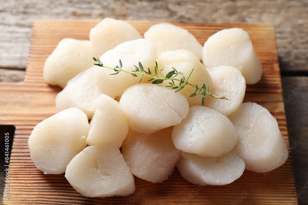 Fresh raw scallops and thyme on wooden table, closeup Fresh raw scallops and thyme on wooden table, closeup