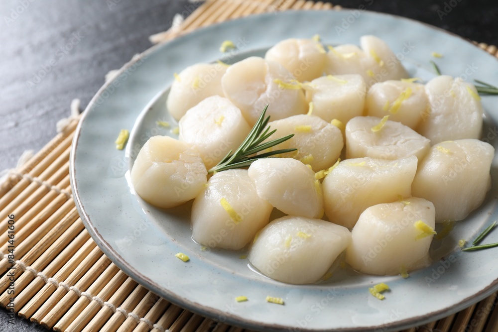 Raw scallops with lemon and rosemary on dark table, closeup Raw scallops with lemon and rosemary on dark table, closeup