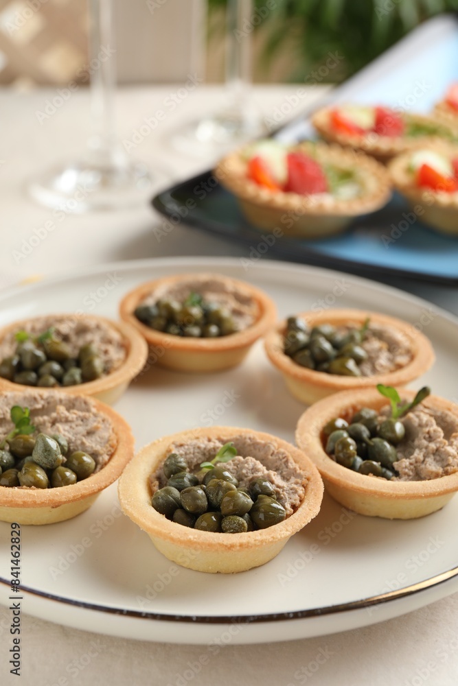 Delicious canapes with pate and capers on white table, closeup Delicious canapes with pate and capers on white table, closeup