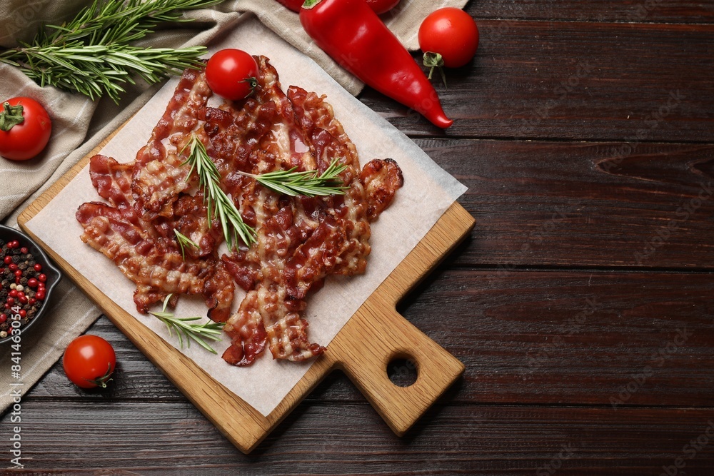 Slices of tasty fried bacon, tomatoes and different spices on wooden table, top view. Space for text Slices of tasty fried bacon, tomatoes and different spices on wooden table, top view. Space for text