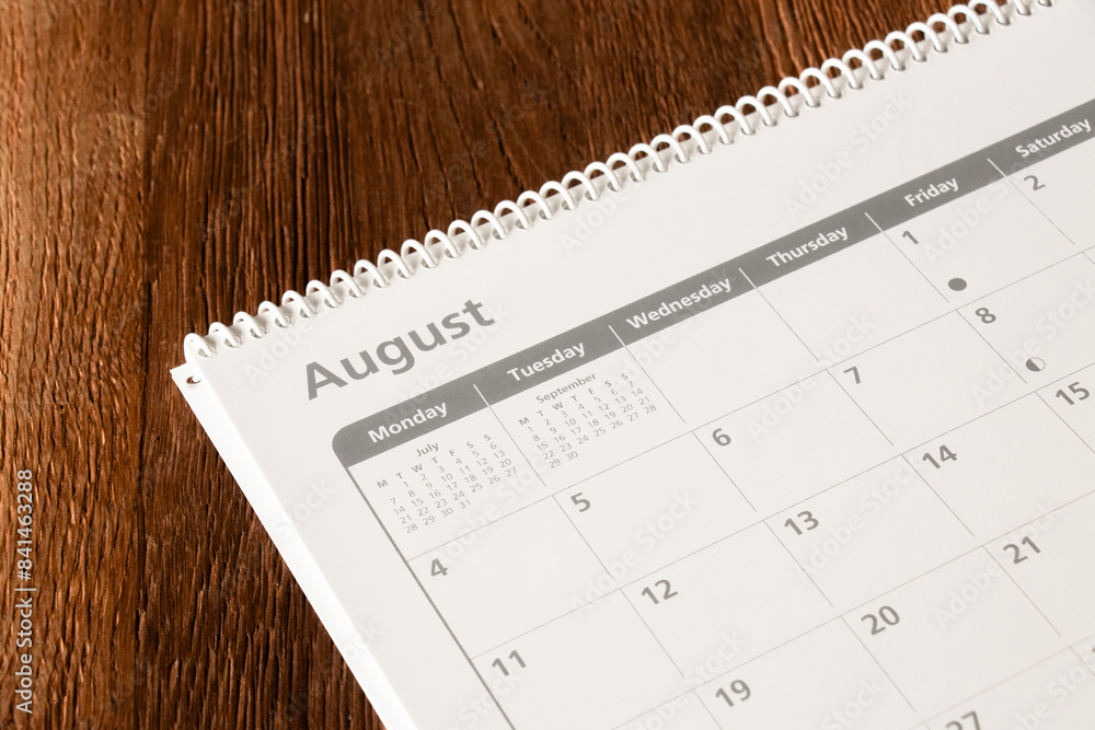 White calendar of the month of August on a wooden background. Planning, goal setting, agenda, planner, organization and time management concept. White calendar of the month of August on a wooden background. Planning, goal setting, agenda, planner, organization and time management concept.
