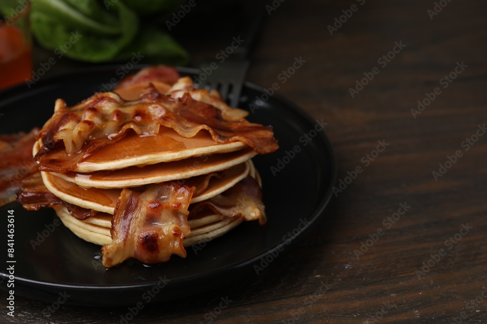 Delicious pancakes with fried bacon served on wooden table, closeup. Space for text Delicious pancakes with fried bacon served on wooden table, closeup. Space for text