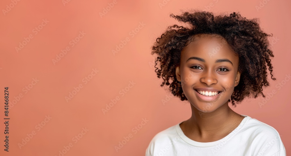 Close up young smiling african american woman in white t-shirt isolated on orange background Close up young smiling african american woman in white t-shirt isolated on orange background