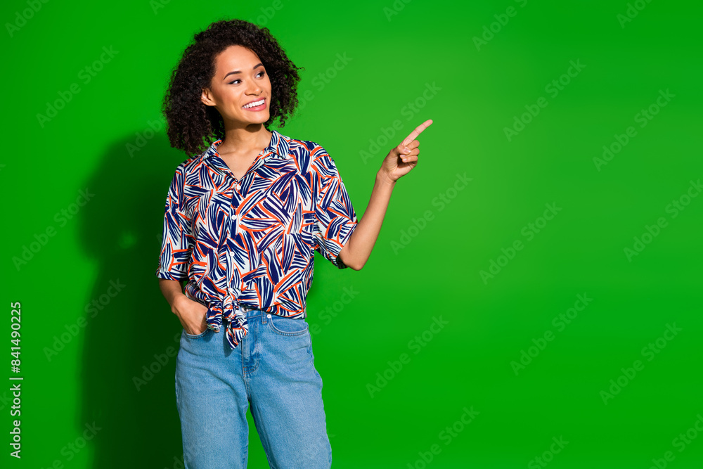 Photo of shiny attractive lady dressed print shirt looking pointing empty space isolated green color background Photo of shiny attractive lady dressed print shirt looking pointing empty space isolated green color background