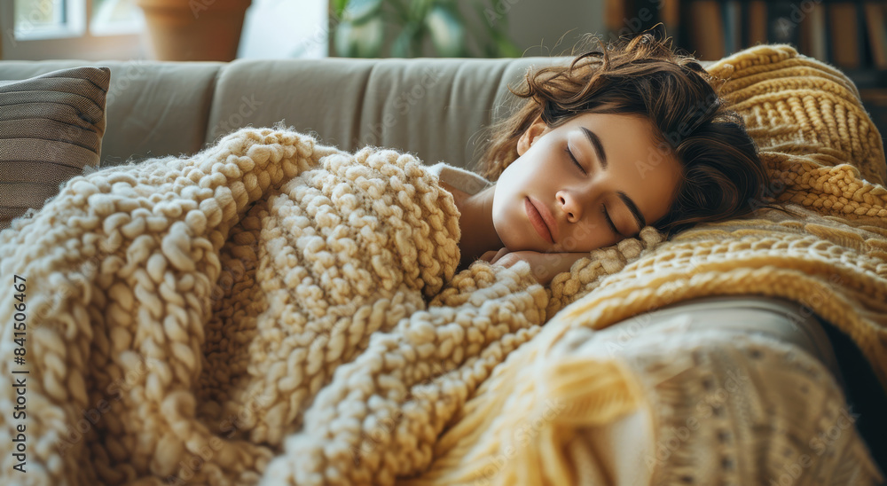 On a couch covered in a blanket, a sick woman takes a nap. Generative AI. On a couch covered in a blanket, a sick woman takes a nap. Generative AI.