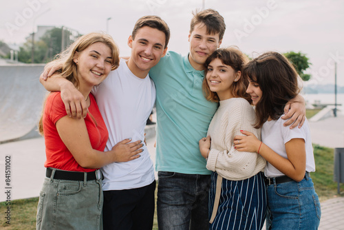 Summer holidays and teenage concept - group of smiling teenagers hanging out outside.